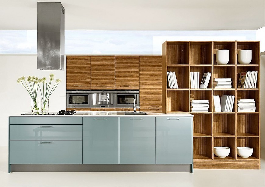 Isla de cocina con armarios columnas con electrodomésticos integrados y estantería en azul acero y zebrano