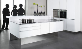La superficie de cristal satinado permanece en un discreto segundo plano para ceder protagonismo a la perfección minimalista. La elegancia perfecta. Un gran detalle: Gracias a los zócalos de espejo los muebles parecen flotar en la estancia. Zuordnung: Stil Cocinas modernas, Planungsart Cocinas en línea