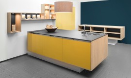 La cara soleada de esta cocina “suspendida” con isla inmediato genera buen humor. A juego el frente con el nombre &quot;Sunny&quot;. El cálido resplandor en color amarillo mate en perfecta armonía con los costados y los estantes modernos de madera clara. El diseño se complementa con un amarillo cálido llamado &quot;Grain&quot;. Zuordnung: Stil Cocinas de diseño, Planungsart Cocinas con isla