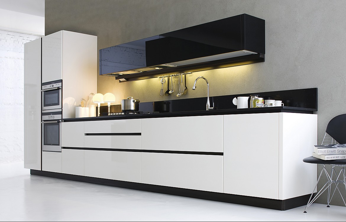 Cocina en blanco y negro en materiales nobles: El diseño purista, la línea de muebles de cocina en blanco destaca enmarcada por la encimera y los armarios altos en negro. Zuordnung: Stil Cocinas de diseño, Planungsart Cocinas en línea