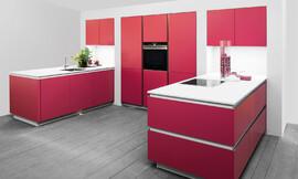 Esta cocina sin tirador de Rotpunkt llama inmediatamente la atención. Los frentes brillan en mate Tulip Red, un tono rojo exclusivo. Zuordnung: Stil Cocinas modernas, Planungsart Cocinas en U