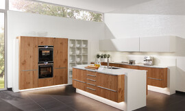 La utilización de la madera como actor principal de esta cocina le da un carácter muy natural, que con la utilización de líneas puras en el diseño le da un toque de elegancia casi extravagante. La utilización de madera de roble noble con una beta muy marcada para el chapado de los frentes le da el carácter inconfundible a esta cocina. Por supuesto la madera ha sido tratada para que sea resistente incluso a los trabajos más duros que se llevan a cabo en la cocina. Zuordnung: Stil Cocinas clásicas, Planungsart Detalles del diseño