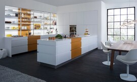 Esta cocina blanca, compacta, sin tiradores de líneas puras, se convierte, con el toque de color cúrcuma que nos transporta a otros tiempos, en una cocina clara, abierta, ligera y funcional. La alegría del color cúrcuma se contagia a toda la estancia y también a los que viven y trabajan allí. Esta cocina es algo más que un pensadísimo lugar de trabajo. Sus magníficos armarios y electrodomésticos están pensados hasta el último detalle para hacernos la vida más fácil, Esta cocina, con sus contrastes de luz y de color, está pensada para hacernos más felices. Zuordnung: Stil Cocinas de diseño, Planungsart Cocinas en U