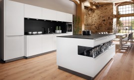 El modelo de cocina Vaso transmite una elegancia atemporal. Destaca por el contraste de colores y materiales: frentes y revestimentos de cristal blanco polar, encimera de la serie a-Top de 20 mm de grosor y chapada de roble negro y entrepaños del mismo material y color rematados con zócalo en metal .  Los revestimentos de la isla también son del mismo material. El contraste blanco y negro le da a esta cocina de diseño la elegancia y el clasicismo que desprende. Zuordnung: Stil Cocinas de diseño, Planungsart Cocinas con isla