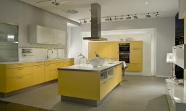 Una isla de cocina con frentes en amarillo mango y elementos, como la encimera, en blanco Zuordnung: Stil Cocinas modernas, Planungsart Cocinas con isla