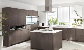 Esta cocina de la línea Forestline emana un encanto rústico y profundamente natural, que promete inmediatamente un ambiente hogareño. La madera de color marrón oscuro de los frentes con estructura de paneles vertical, da a esta cocina de madera una nota misteriosa. Zuordnung: Stil Cocinas clásicas, Planungsart Cocinas con isla