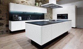 Modern ART CONTURA, una cocina blanca de alto brillo, es algo más que una cocina Vintage. Esta cocina de diseño creada en los años 70, actualizada con detalles como los frentes sin tiradores y perfeccionada con el redondeado de los cantos y con complementos, como la encimera de &quot;stoneline&quot; de granito Absolut, nos permite disfrutar del ambiente del pasado sin renunciar a las ventajas de los avances del presente. Zuordnung: Stil Cocinas de diseño, Planungsart Cocinas con isla