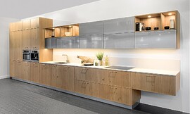 Natural y moderna a la vez: Esta cocina es un término medio, que hace agradable el ambiente. Lo frentes de los armarios bajos y de las columnas está hecha de chapa de roble en un acabado claro. Los armarios altos de esta cocina son de cristal opaco, dan un toque moderno y combinan a la perfección con los estantes. Zuordnung: Stil Cocinas de diseño, Planungsart Cocinas con isla