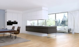 Esta isla de cocina con placa de cocción y área de trabajo es accesible desde tres de sus lados. Funciona como elemento de conexión de la sala de estar de la cocinas. Zuordnung: Stil Cocinas de lujo, Planungsart Cocinas con isla