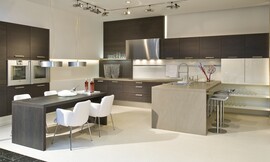 Cocina en forma de U con frentes oscuros de madera de roble. Esta cocina tiene un carácter muy especial gracias a las diferentes alturas de los armarios altos y de columna, los armarios bajos colgantes y la mezcla de materiales y colores de las diferentes áreas de trabajo. La cocina se convierte en una sala más de la casa que transmite amplitud y comodidad e invita a disfrutar de la buena compañía. Zuordnung: Stil Cocinas modernas, Planungsart Cocinas en línea