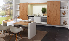 Naturaleza pura y sin embargo de una elegancia extravagante. La exclusiva madera de roble con una beta especial marca el carácter de esta cocina única. La superficie tratada con aceites naturales le garantiza la resistencia necesaria para la el trabajo diario en la cocina 
„zeyko home“ – es el concepto flexible que trata de unir la cocina con la sala de estar. Las zonas de trabajo de la cocina desaparecen detrás de unas puertas correderas elegantemente decoradas que hacen desaparecer la cocina tras una estantería de libros. Zuordnung: Stil Cocinas clásicas, Planungsart Cocinas en línea
