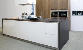 Cocina de diseño moderno que combina laca y madera. Detalle exclusivo: zócalo de lamas en aluminio y el fregadero enrasado en la encimera de estratificado de 17mm. Zuordnung: Stil Cocinas modernas, Planungsart Cocinas con isla