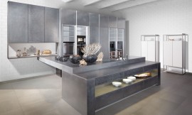 Exclusiva cocina de diseño con superficies hechas a mano. El metal fundido se extiende con la ayuda de una espátula y se barniza con una laca que le otorga la resistencia que requiere el trabajo en la cocina. Los electrodomésticos de cocina desaparecen detrás de las puertas de metal. Zuordnung: Stil Cocinas de lujo, Planungsart Cocinas con isla