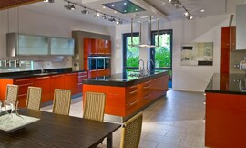 Cocina americana con armarios altos de puertas plegables y encimera negra brillante Zuordnung: Stil Cocinas modernas, Planungsart Cocinas con isla