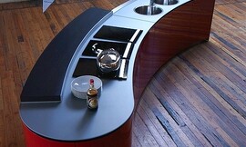 Se trata de una barra de cocina accesible por ambos lados con una encimera extraplana. El contraste de colores del rojo y el negro subrayan el diseño moderno de esta cocina. Zuordnung: Stil Cocinas modernas, Planungsart Cocinas con isla