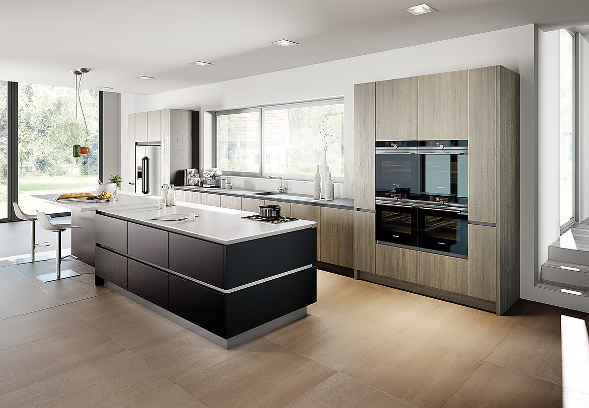 Esta cocina de diseño ofrece suficiente superficie de trabajo. Tiene una gran isla en negro mate con barra de desayuno y asientos que acaba con una encimera blanca. En el diseño de la zona del lavabo se recurrió a un frente de madera clara. Zuordnung: Stil Cocinas de diseño, Planungsart Cocinas en línea