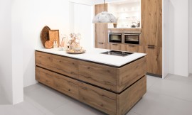 Cocina de diseño acogedor, con una decoración de madera en Old Wild Oak. La característica especial aquí está en los detalles: El frente de la isla de la cocina tiene una estructura horizontal de madera, mientras que los armarios altos están decorados con una estructura de madera vertical. Zuordnung: Stil Cocinas clásicas, Planungsart Cocinas con isla