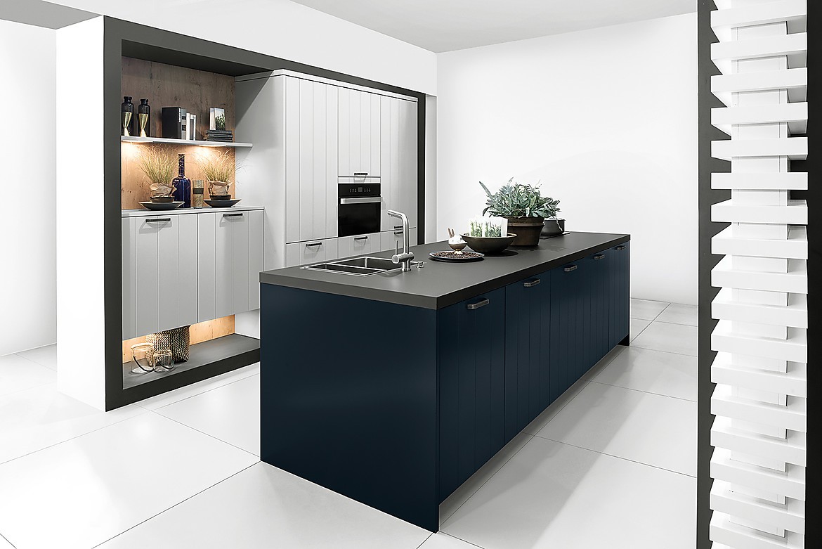 Como la noche y el día, y sin embargo, lleno de armonía: la cocina con isla en Midnight Blue ofrece un atractivo contraste con los frentes claros en Daylight Grey . En esta cocina de diseño se funde la belleza clásica y la modernidad en un todo armonioso. Los frentes con textura ondulada son muy agradables a la vista, por eso también son adecuados para cocinas rústicas. Zuordnung: Stil Cocinas de diseño, Planungsart Cocinas con isla