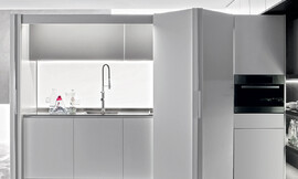 El toque especial: la cocina blanca con muebles en línea de frentes blancos y un práctico sistema de puertas correderas que si lo desea hacen desaparecer la zona de trabajo de la cocina, permitiéndole disfrutar de una sala perfectamente ordenada. Zuordnung: Stil Cocinas de diseño, Planungsart Cocinas en línea