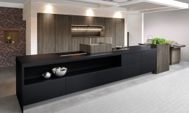 Cocina de diseño purista con los frentes sin tirador. El color negro de la isla se funde con el color de madera oscuro Late Oak de los armarios altos y crea una bonita composición. Zuordnung: Stil Cocinas de diseño, Planungsart Cocinas con isla