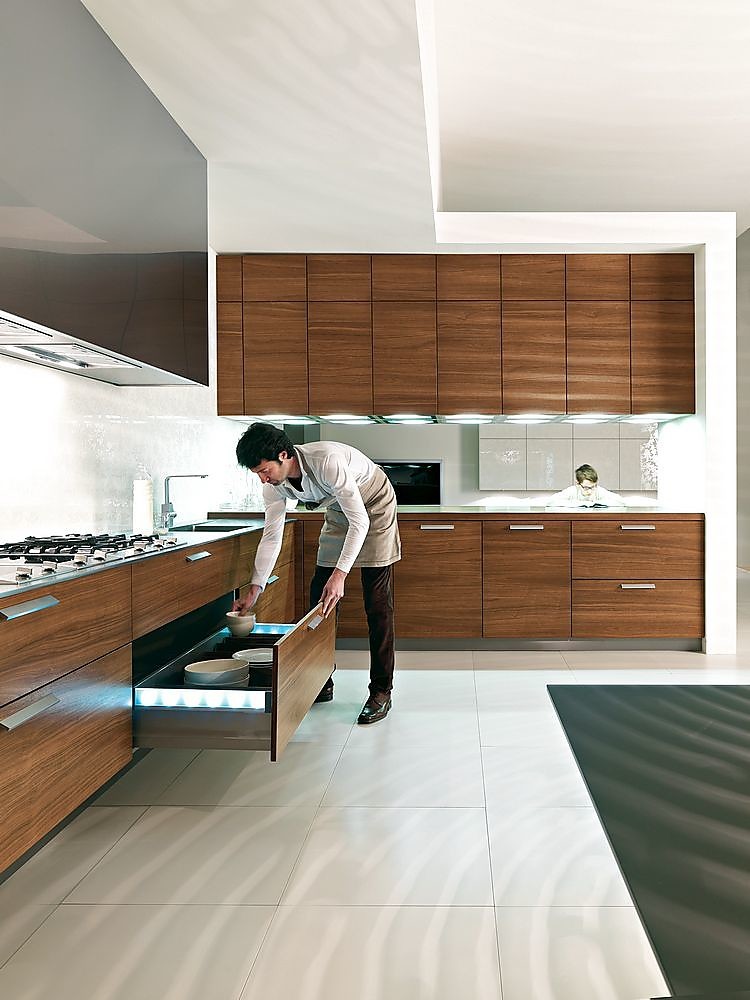 Cocina en L de nogal, acero y blanco con elementos de iluminación