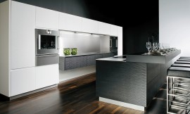 Modern ART WAVE con superficies que forman suaves ondas. El lacado de lujo brillo diamante en blanco y negro destaca junto a la encimera de acero con el fregadero integrado. Zuordnung: Stil Cocinas de diseño, Planungsart Cocinas con isla