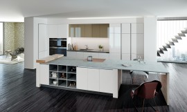 Diseño de cocina refinado: La zona del lavabo y los armarios blancos se alejan visualmente y se funden con la pared. La gran isla con frentes si tirador,  puntua con sus detalles prácticos tales como la estantería abierta y la mesa. Zuordnung: Stil Cocinas de diseño, Planungsart Cocinas con isla