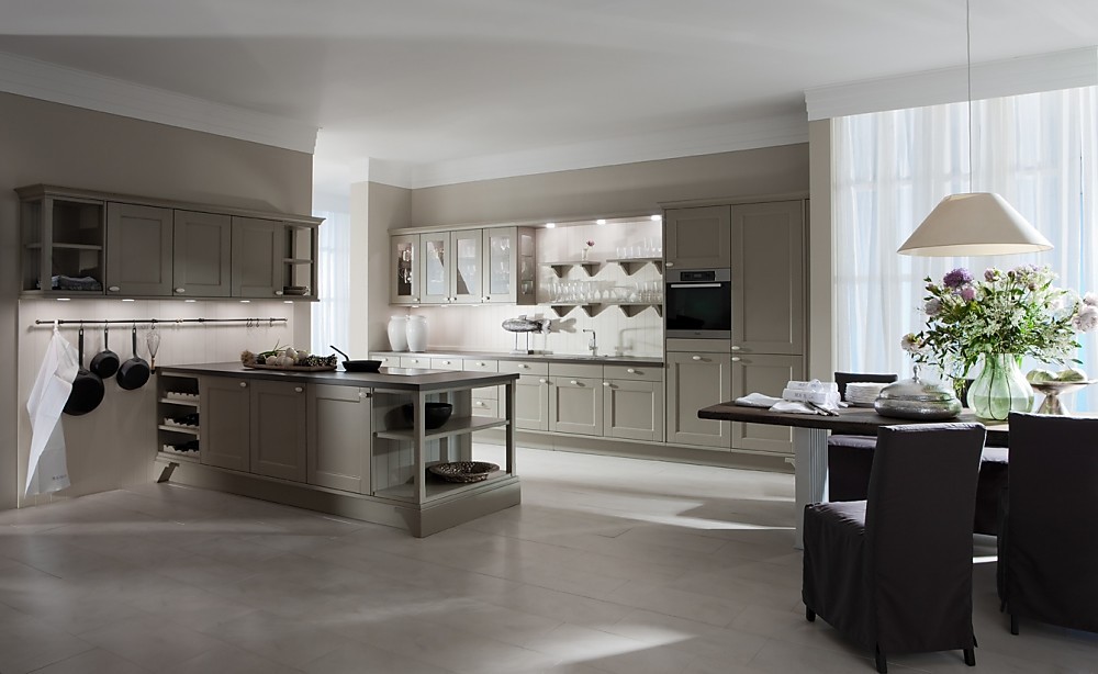 Elegancia en lacado gris mate. Las puertas enmarcadas en gris junto al juego con la luz y el uso del color blanco son los elementos principales de esta cocina de un estilo clásico actualizado. Detalles como las vitrinas con lados de cristal o los tiradores de estilo vintage remarcan el estilo clásico. La sensación de amplitud que transmite esta cocina también ayuda a crear ese ambiente de bienestar que desprende esta sala de estilo atemporal. Si el gris no es su color la empresa LEICHT ofrece el mismo modelo en 200 tonalidades diferentes. Zuordnung: Stil Cocinas rústicas, Planungsart Cocinas con isla