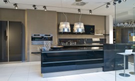 Esta isla de diseño muy moderno con barra y con armarios columna donde están integrados los electrodomésticos. El diseño se une a la funcionalidad en esta cocina abierta en la que el color negro de los frentes de alto brillo le da un carácter muy elegante. Zuordnung: Stil Cocinas modernas, Planungsart Cocinas en U