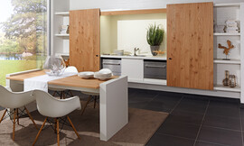 Naturaleza pura y sin embargo de una elegancia extravagante. La exclusiva madera de roble con una beta especial marca el carácter de esta cocina única. La superficie tratada con aceites naturales le garantiza la resistencia necesaria para la el trabajo diario en la cocina 
„zeyko home“ – es el concepto flexible que trata de unir la cocina con la sala de estar. Las zonas de trabajo de la cocina desaparecen detrás de unas puertas correderas elegantemente decoradas que hacen desaparecer la cocina tras una estantería de libros. Zuordnung: Stil Cocinas clásicas, Planungsart Cocinas en línea