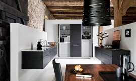 Los armarios de roble negro dan el toque de elegancia a esta estancia donde la arquitectura permite pasar de una cocina funcional a una acogedora sala de estar gracias a los armarios colgantes y los tonos oscuros de la madera de robles. Zuordnung: Stil Cocinas modernas, Planungsart Detalles del diseño