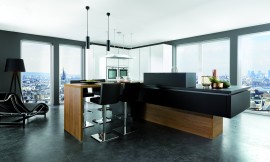 Esta cocina le permitirá disfrutar de un ambiente de líneas puras, espacios ordenados y un diseño que invita a la relajación. 
Los armarios altos blancos en laca alto brillo permiten organizar el almacenamiento de los enseres necesarios en una cocina a la vez de permitir un elegante encastre de los electrodomésticos. La isla de líneas claras sin ornamentos permite organizar la zona de trabajo y satisfacer las necesidades de espacio para realizar las tareas cotidianas. Zuordnung: Stil Cocinas de diseño, Planungsart Cocinas con isla