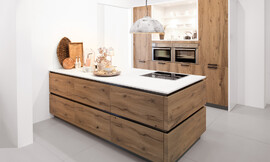 Cocina de diseño acogedor, con una decoración de madera en Old Wild Oak. La característica especial aquí está en los detalles: El frente de la isla de la cocina tiene una estructura horizontal de madera, mientras que los armarios altos están decorados con una estructura de madera vertical. Zuordnung: Stil Cocinas de diseño, Planungsart Cocinas en línea