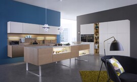 Cocina de arquitectura abierta, transmite a todo su hogar la elegancia de las líneas puras de sus muebles, que colgados en la pared o apoyados en elegantes patas de diseño, dan una sensación de ligereza casi etérea. La mezcla de colores y texturas, el roble cobrizo de los muebles bajos y el lacado Sahara de los muebles altos, crean un contraste de color en la sala, que subraya su elegancia natural. [[more]] Una elegante y delicada encimera de cerámica realza el carácter natural. Las baldas luminosas y los elementos de iluminación repartidos por la cocina destacan los detalles y relajan las formas, permitiéndole dar a su cocina el toque personal que se merece. La instalación de la campana extractora Plasma Norm, completamente integrada en los muebles y extremadamente silenciosa, le invita a integrar esta elegante cocina en su sala de estar. Zuordnung: Stil Cocinas clásicas, Planungsart Cocinas en L