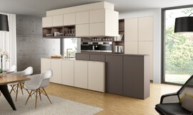La elección de los colores blanco magnolia y moca, combinado con la distribución de la luz y los diferentes materiales empleados ayudan a construir una sensación de espacios diferentes unidos por la elegancia que trasmite esta sala. Pero los muebles de esta cocina con isla también esconden innovaciones, como los muebles altos sobre la encimera o los muebles colgantes sobre la isla, que ayudan a facilitar el trabajo en la cocina. Zuordnung: Stil Cocinas de diseño, Planungsart Cocinas americanas (abiertas)
