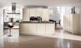 Moderno, luminoso y agradable: En los frentes lacados sin tirador de esa cocina en isla, la luz se refleja de manera especialmente atractiva. El confortable bar invita a sentarse y relajarse. Zuordnung: Stil Cocinas de diseño, Planungsart Cocinas con isla