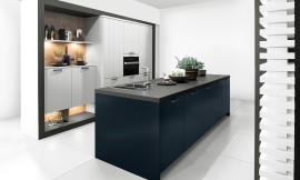 Como la noche y el día, y sin embargo, lleno de armonía: la cocina con isla en Midnight Blue ofrece un atractivo contraste con los frentes claros en Daylight Grey . En esta cocina de diseño se funde la belleza clásica y la modernidad en un todo armonioso. Los frentes con textura ondulada son muy agradables a la vista, por eso también son adecuados para cocinas rústicas. Zuordnung: Stil Cocinas de diseño, Planungsart Cocinas con isla