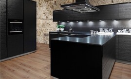 NATURA cocina chapada en madera lacada en negro. Los armarios columna Modern ART Verticon y los armarios altos ART TIP-TEC equipados con el sistema mecánico de apertura de puertas Sensomatic destacan junto a la encimera „stoneline“ Granit Nero satinado. Zuordnung: Stil Cocinas de diseño, Planungsart Cocinas americanas (abiertas)