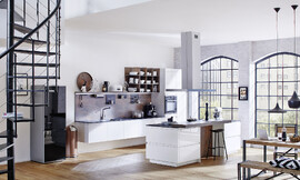 El arte del  diseño no necesita mucho espacio: Eso lo demuestra este ejemplo de cocina de Rotpunkt. La zona del lavabo encanta por su ligereza noble. Os armarios bajos están montados sobre la pared sin zócalo, por lo tanto, parece que la cocina esta flotando en el aire. Zuordnung: Stil Cocinas modernas, Planungsart Cocinas con isla