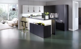 Los costados, la barra y el entrepaño son del mismo material negro que la encimera, lo que le da continuidad al conjunto y contrasta con los frentes de cristal blanco mate de los armarios bajos. La gran protagonista de esta cocina es la encimera de Corian de 13 mm de espesor. Zuordnung: Stil Cocinas de diseño, Planungsart Cocinas americanas (abiertas)