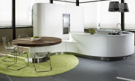 Cocina blanca de frentes sin tiradores. Sus líneas curvas favorecen la continuidad y la unión de espacios. Su diseño moderno y minimalista convierte la cocina en el centro de un hogar donde reinan el estilo y la comodidad. Zuordnung: Stil Cocinas de lujo, Planungsart Cocinas con isla