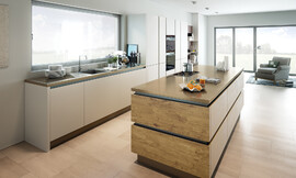 Esta cocina de diseño, sin tirador, debido a su diseño lineal y angular es de apariencia muy moderna. Los frentes lacados en color Stone mate subrayan este diseño muy moderno. Sin embargo, la comodidad no se descuida. La isla se realza gracias a sus frentes en imitación madera. Zuordnung: Stil Cocinas de diseño, Planungsart Cocinas en L