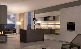 El centro de esta sala es una pared de armarios empotrados cubierta con un panel flexible que cumple dos funciones: separar la zona de estar de la cocina y convertirse en el centro que transmite personalidad a la sala. Zuordnung: Stil Cocinas clásicas, Planungsart Cocinas con isla
