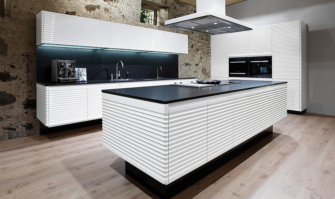 Modern ART CONTURA, una cocina blanca de alto brillo, es algo más que una cocina Vintage. Esta cocina de diseño creada en los años 70, actualizada con detalles como los frentes sin tiradores y perfeccionada con el redondeado de los cantos y con complementos, como la encimera de &quot;stoneline&quot; de granito Absolut, nos permite disfrutar del ambiente del pasado sin renunciar a las ventajas de los avances del presente. Zuordnung: Stil Cocinas de diseño, Planungsart Cocinas con isla