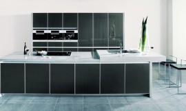 Esta cocina elegante y de líneas puras en tonos metálicos con frentes de cristal y marcos metálicos. Con una isla de cocina con encimera en dos alturas no deja un detalle suelto para que pueda disfrutar de su cocina en todo momento Zuordnung: Stil Cocinas de diseño, Planungsart Cocinas americanas (abiertas)