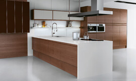 La encimera y los frentes de los armarios altos en blanco otorgan el marco perfecto para esta cocina clásica que sorprende por los detalles de modernidad, como la balda iluminada o la placa de cocción de líneas curvas. Zuordnung: Stil Cocinas modernas, Planungsart Cocinas en línea